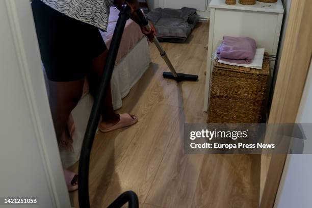 Domestic worker cleans with a vacuum cleaner on the day that unemployment benefits for domestic workers were approved, on September 6 in Madrid,...