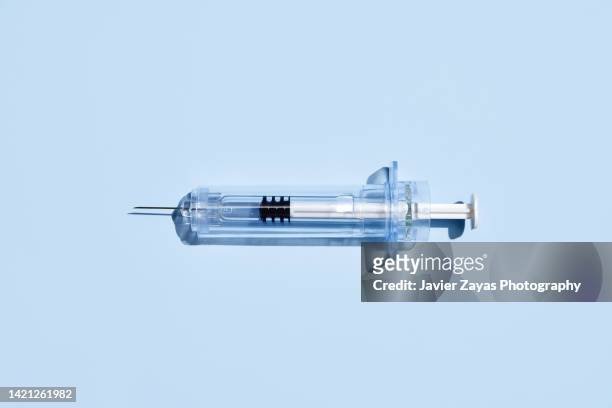 syringe on blue background - steroids stock pictures, royalty-free photos & images