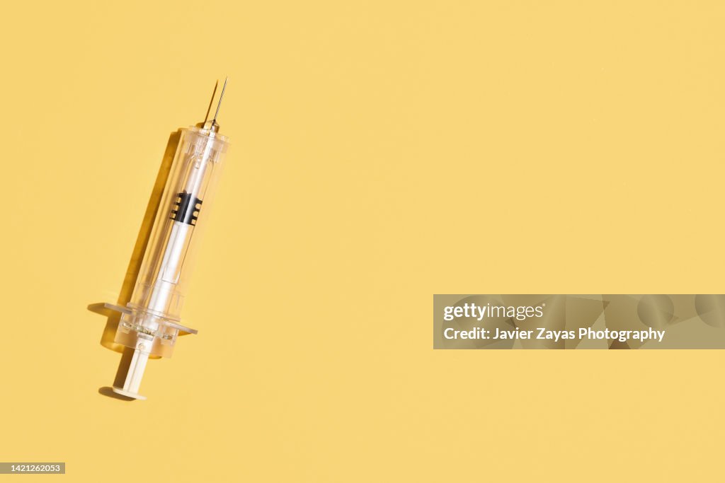 Syringe On Yellow Background