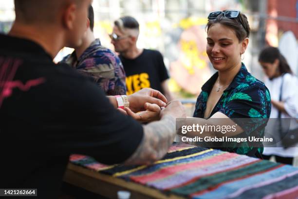 People receive the entry bracelets to a festival “Na Chasi” on August 27, 2022 in Kyiv, Ukraine. The charity festival of modern music and visual art...