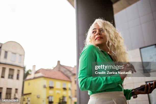 shot of a mature businesswoman outside office using phone looking over shoulder - boss over shoulder stock pictures, royalty-free photos & images