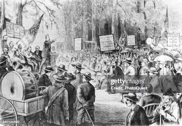 Engraving of an open-air meeting held by the Granges, an populist farmer's association organized in the western United States, where a speaker hold...