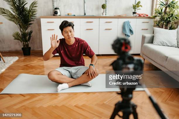 young man filming a vlog on exercising at home - fitness instructor at home stock pictures, royalty-free photos & images
