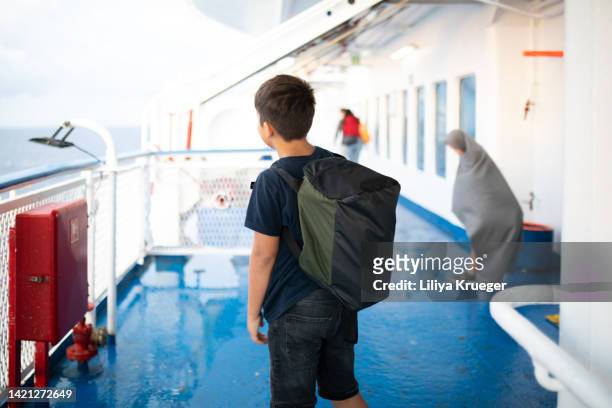 a boy with a backpack travels on the ferry, back view. - cruise port photos et images de collection