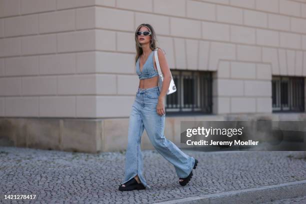 Sophia Geiss is seen wearing silver shades, blue denim Source Unknown cropped bra top, matching wide leg blue denim pants, Source Unknown silver...