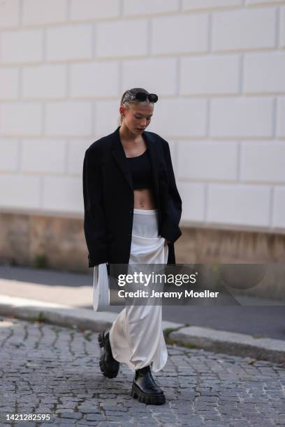 Sophia Geiss is seen wearing Prada Symbole black shades, LeGer black cropped top, vintage black oversized blazer, NA-KD silk white/beige long skirt,...