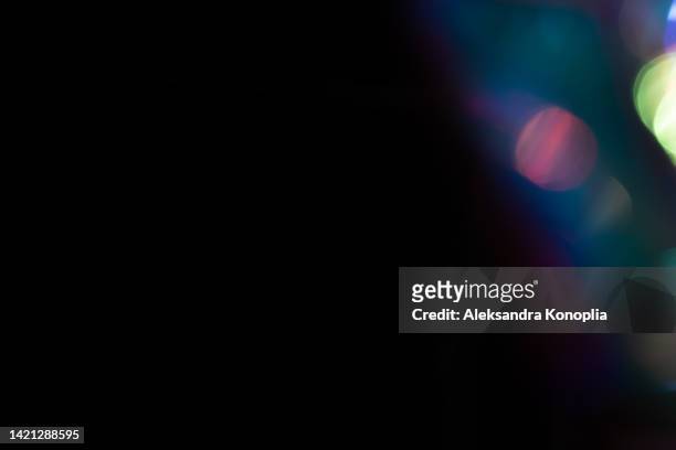 colorful neon holographic light leaks on black background - lens flares stock-fotos und bilder