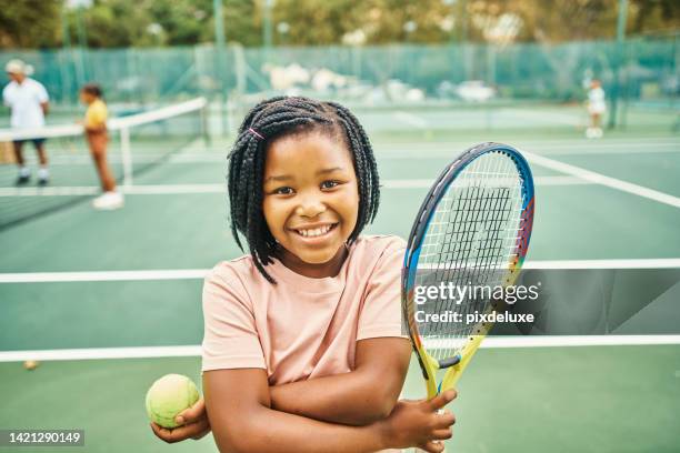 portrait d’une jeune joueuse de tennis africaine avec des équipements sportifs pour la croissance, le développement et le progrès du sport sur un court de tennis. enfant avec raquette de tennis et balle au camp d’entraînement ou au club pour la pra - balle de tennis photos et images de collection