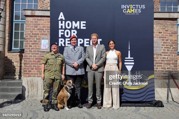 Prince Harry, Duke of Sussex and Meghan, Duchess of Sussex pose with competitors from the previous Invictus games during the Invictus Games...