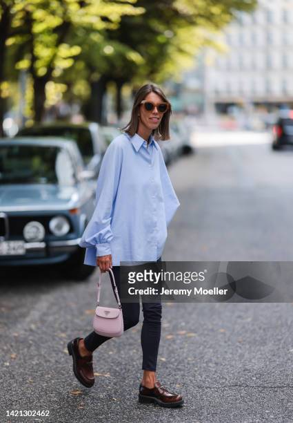 Katrin Lehbruner is seen wearing Prada brown leather loafer, Prada mini Cleo bag, SoSue black leggings, SoSue blue blouse on September 02, 2022 in...