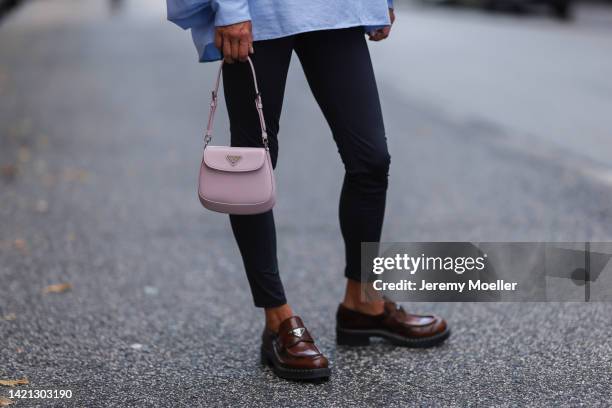 Katrin Lehbruner is seen wearing Prada brown leather loafer, Prada mini Cleo bag, SoSue black leggings, SoSue blue blouse on September 02, 2022 in...