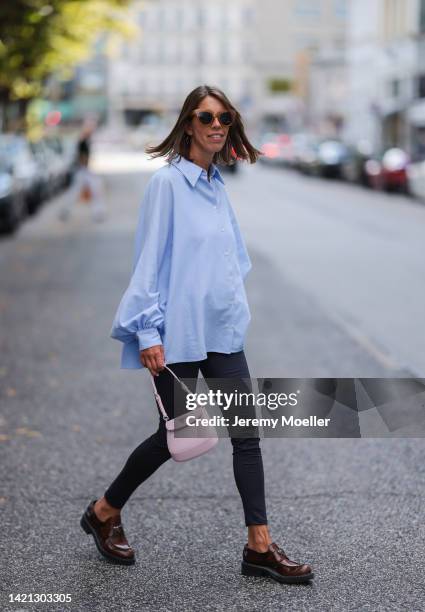 Katrin Lehbruner is seen wearing Prada brown leather loafer, Prada mini Cleo bag, SoSue black leggings, SoSue blue blouse on September 02, 2022 in...