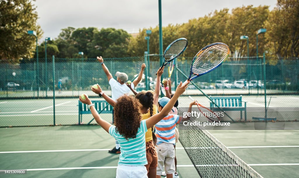 Children learning tennis in fitness class at school, training for sports game on court and kids in line for sport education. Students, friends and athlete playing on playground for competition