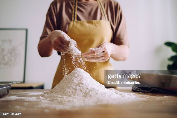 anonymous woman adding and preparing flour for kneading - levedura imagens e fotografias de stock
