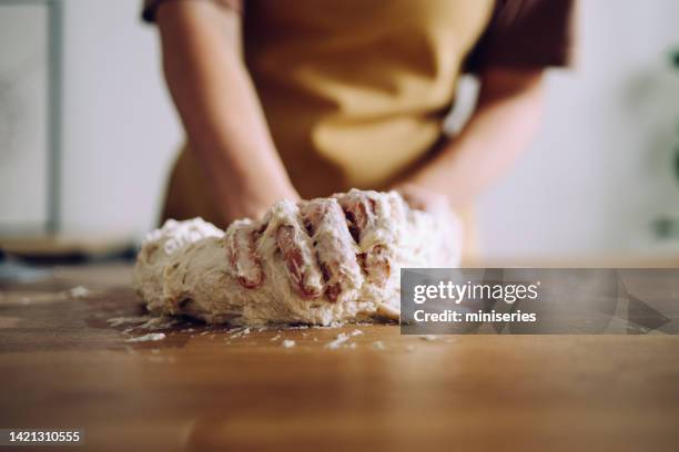 anonymous woman kneading the dough with her hands for a homemade bread - knåda bildbanksfoton och bilder