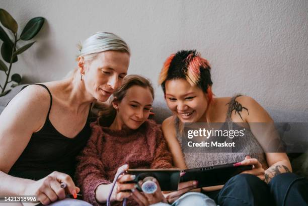 happy gay couple using wireless technologies at home - lgbt mobile foto e immagini stock