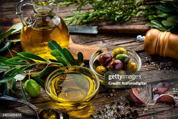 olives and extra virgin olive oil on rustic table - extra virgin olive oil stock pictures, royalty-free photos & images