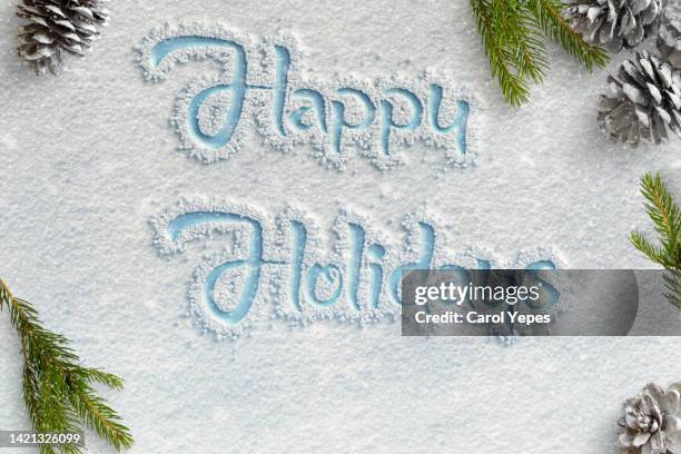 happy holidays written in the snow. winter and christmas time - alphabet hand made stock-fotos und bilder