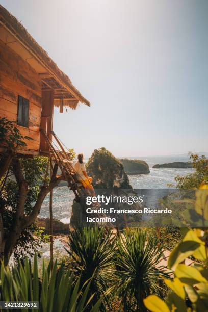 woman and tree house, nusa penida, bali, indonesia - island hut stock pictures, royalty-free photos & images