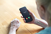 Phone call to old woman from scam or fraud caller. Elder senior answering to unknown number. Smartphone scammer or mobile hoax, catfish or phishing concept. Stalker or stranger.