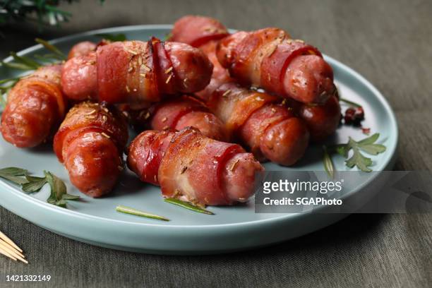 pigs in blanket - bacon stockfoto's en -beelden