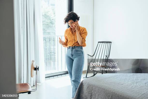 a beautiful businesswoman talking to somebody on her mobile phone - bel appartement stockfoto's en -beelden