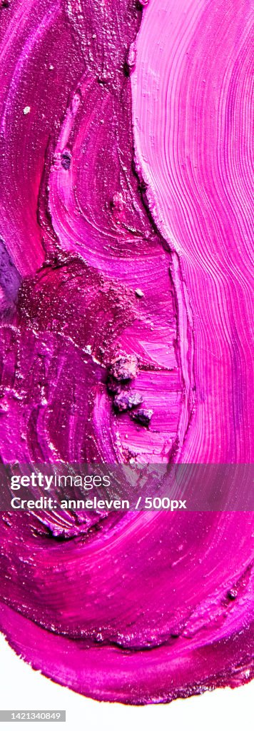 Artistic lipstick smudge and crushed eyeshadow as background