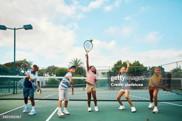 happy and fun tennis playing children with racket on a court at a sports club. training, fitness and practice during a lesson with kids learning to play game or sport for health wellness and fitness - sports training camp stock pictures, royalty-free photos & images