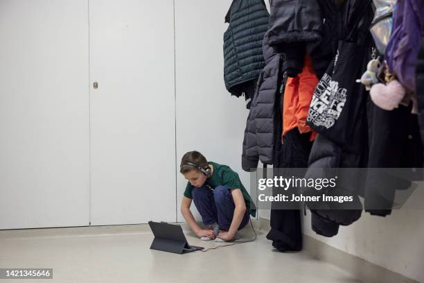 boy using digital tablet in changing room - young boys changing in locker room stock pictures, royalty-free photos & images