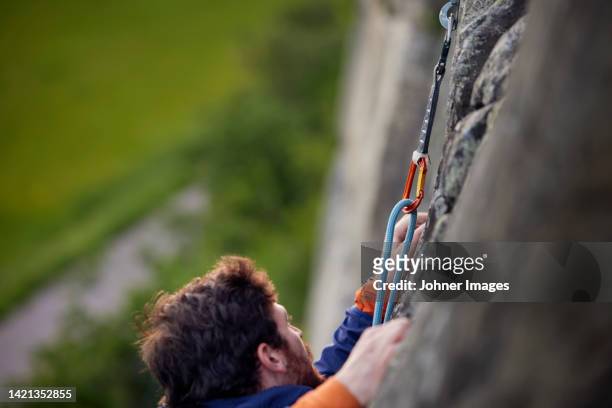 close-up of man rock climbing - karabijnhaak stockfoto's en -beelden
