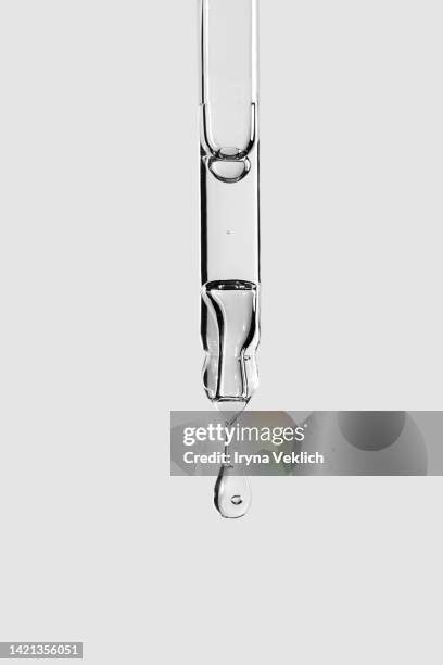 pipette with face serum or essential oil with oxygen aqua bubbles and a drop of liquid on a pastel gray color background. - pipeta imagens e fotografias de stock