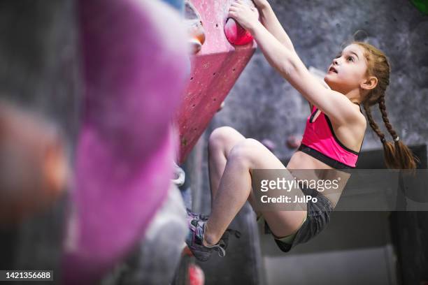 ロッククライミングウォールでトレーニングをしている少女 - modern rock ストックフォトと画像