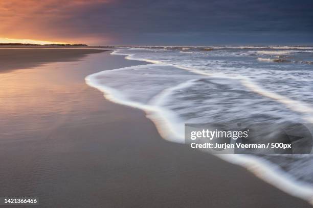 scenic view of beach against sky during sunset,terschelling,netherlands - natuurgebied stock-fotos und bilder