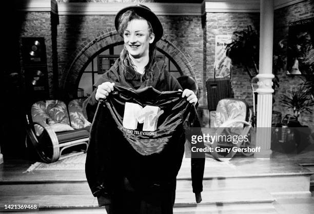 View of British Pop musician Boy George , of the group Culture Club, posing with a MTV-branded jacket during an interview on MTV at Teletronic...
