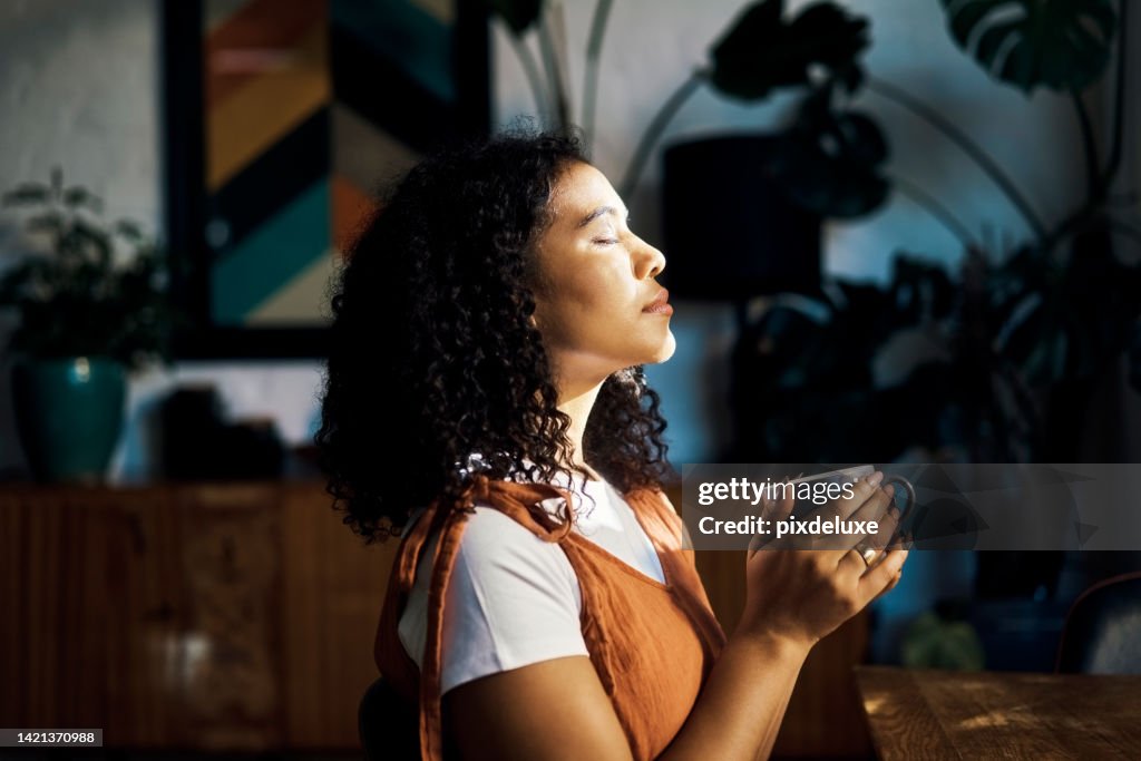 Relax, peace and coffee with a woman drinking a drink of caffeine and meditating in her home with her eyes closed. Mental health, wellness and zen with a young female enjoying calm, quiet tranquility