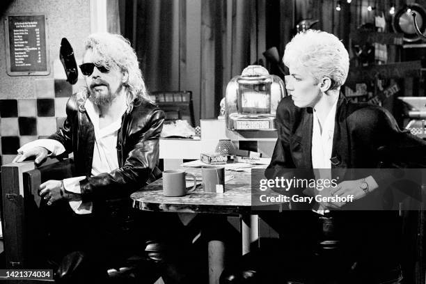 View of English musician Dave Stewart and Scottish musician Annie Lennox, both of the group Eurythmics, as they sit in a diner's booth during an...