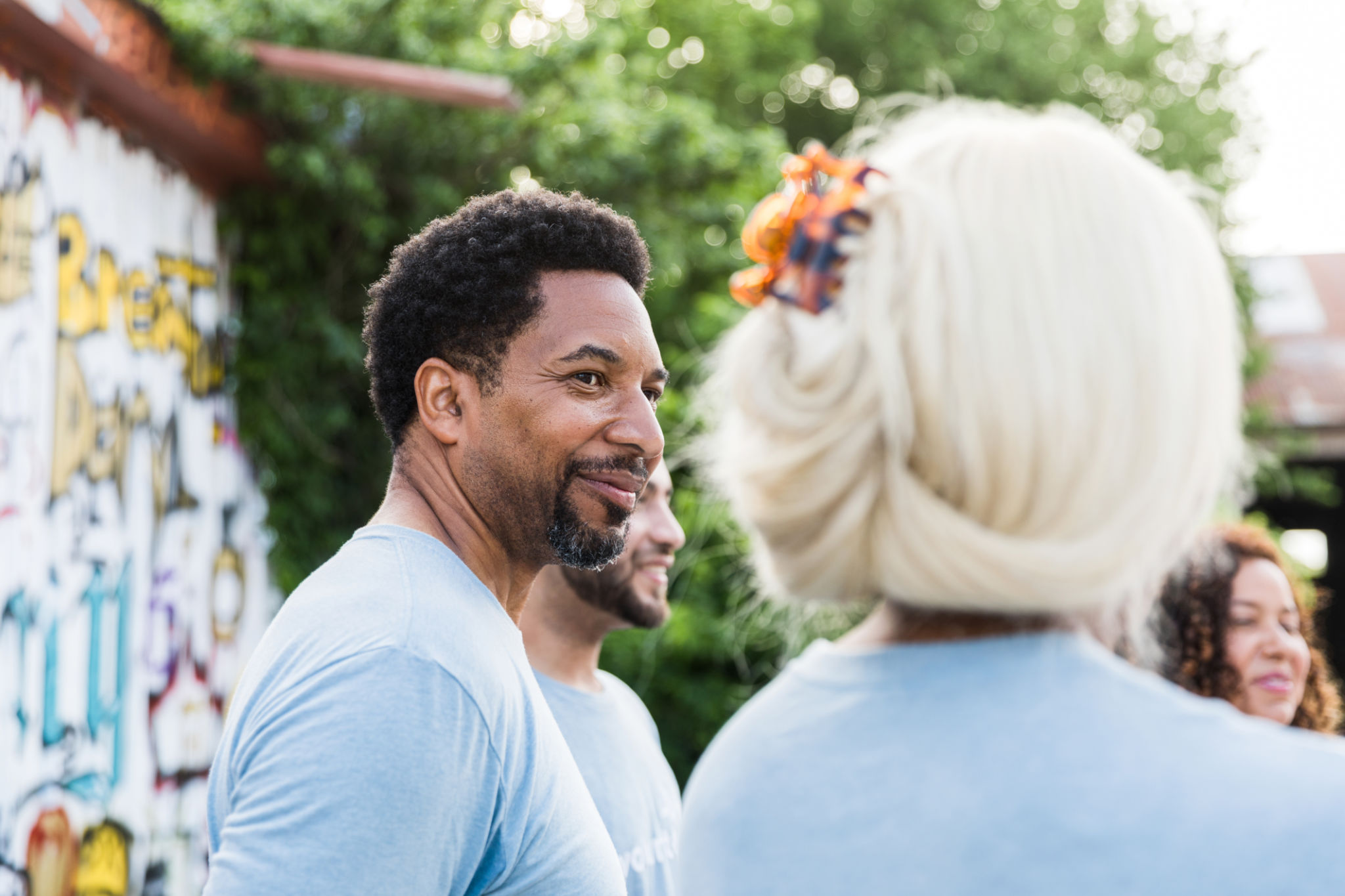 The volunteers stand in a circle and wait for their assignments.