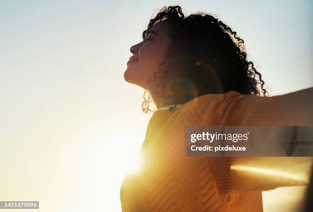 liberté, éclat et ciel avec une femme en plein air au coucher du soleil pendant l’été pour se détendre avec l’air frais et le soleil. heureux, insouciant et maquette avec une jeune femme se sentant détendue dehors le matin - happy woman in early morning sunlight photos et images de collection