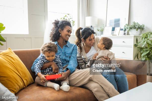 female gay couple with kids at home - lésbica imagens e fotografias de stock