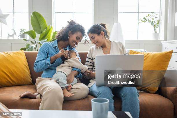pareja gay femenina con niños en casa - lesbicas fotografías e imágenes de stock