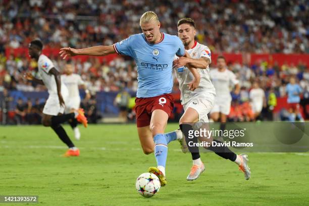 Erling Haaland of Manchester City battles for possession with Jose Angel Carmona of Sevilla FC during the UEFA Champions League group G match between...