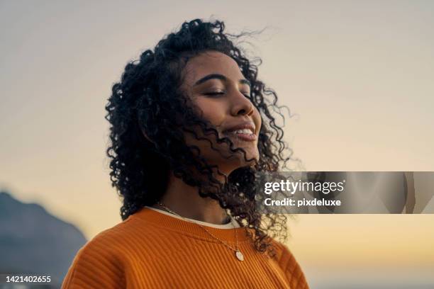femme heureuse dans la nature, coucher de soleil ciel paix et sourire respirant co2. beauté bien-être, ciel extérieur clair et
nouvelle vague de calme. les yeux fermés, l’air de traitement de l’asthme et la fille aux cheveux bouclés visage détend - nature zen photos et images de collection