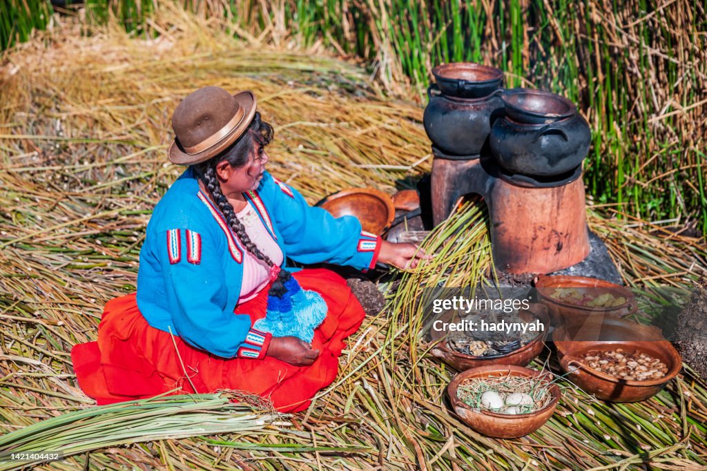 Femme péruvienne cuisinant sur l’île flottante d’Uros, lac Tititcaca