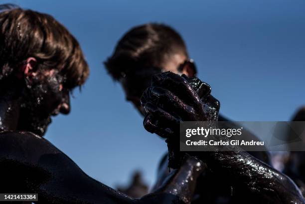 Man greases another before taking part in the festival of Cascamorras on September 06, 2022 in Baza, Spain. After two years of hiatus due to the...