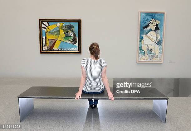 Visitor looks at a set of paintings "Le Couple" and "La Pisseuse" in the exhibition "Women" at the Pinakothek der Moderne at the museum in Munich,...