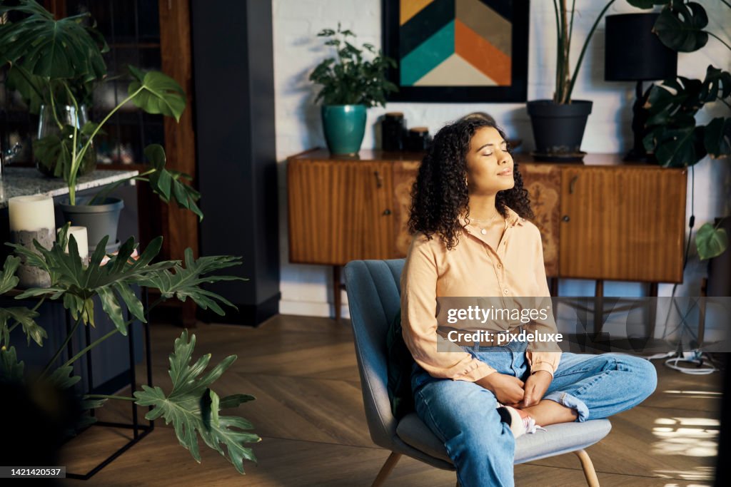 Peace, relax and happy mindset of a woman from Indonesia taking a mind and meditation home break. Happiness of woman on a house living room lounge chair thinking about life, gratitude and self care