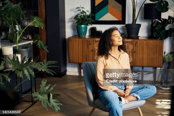 peace, relax and happy mindset of a woman from indonesia taking a mind and meditation home break. happiness of woman on a house living room lounge chair thinking about life, gratitude and self care - serene people stock pictures, royalty-free photos & images