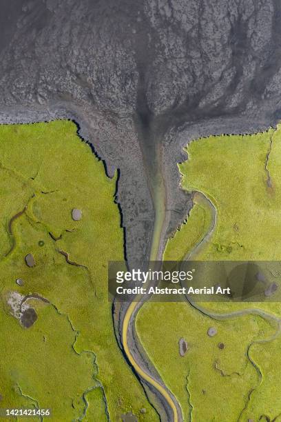 drone image looking down on a river channel flowing across a marshland, iceland - nun river estuary stock-fotos und bilder