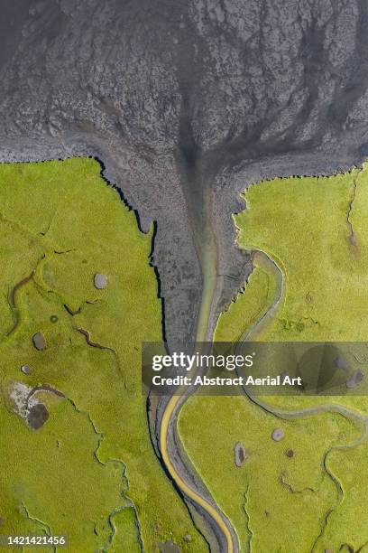 drone image looking down on a river channel flowing across a marshland, iceland - estuario fotografías e imágenes de stock