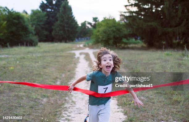 little child runner crossing finish line in a race competition - sprint finish stock pictures, royalty-free photos & images